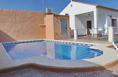 a swimming pool in front of a house at Casa El Cortijillo in Conil de la Frontera