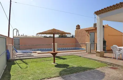 a yard with an umbrella on the roof of a house at Casa El Cortijillo in Conil de la Frontera
