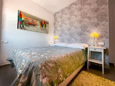 a bedroom with a bed and a table with a lamp at Sunny Sanlucar in Sanlúcar de Barrameda