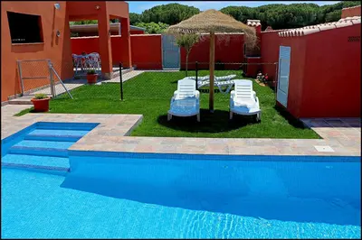 a swimming pool with two lounge chairs and an umbrella at Chalet Maestro in Roche