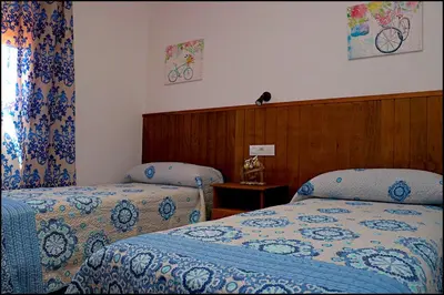 a hotel room with two beds and a window at Chalet Maestro in Roche