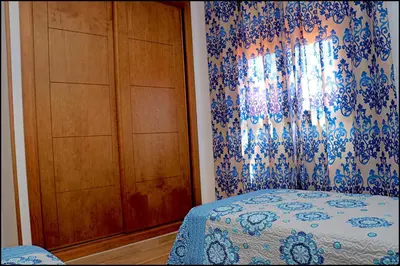 a bedroom with a bed and a dresser and a window at Chalet Maestro in Roche