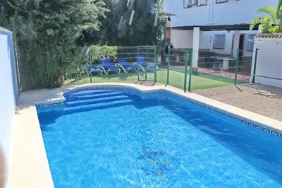 a swimming pool with blue water in a yard at Chalet Pradillo II in Conil de la Frontera