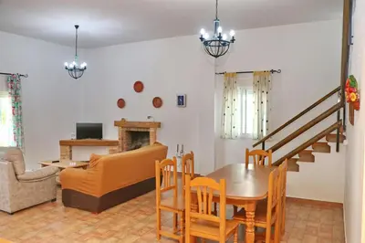 a living room with a table and chairs and a couch at Chalet Pradillo II in Conil de la Frontera