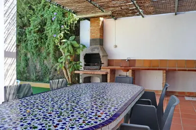 a table and chairs in a patio with a fireplace at Chalet Pradillo II in Conil de la Frontera