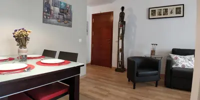 a living room with a table and a chair at Zambra. Luminoso y coqueto apartamento en Chiclana in Chiclana de la Frontera