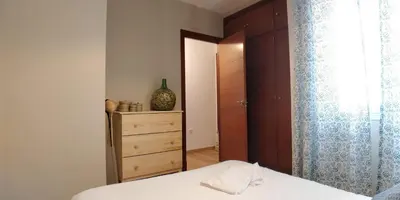 a bedroom with a bed and a dresser and a closet at Zambra. Luminoso y coqueto apartamento en Chiclana in Chiclana de la Frontera