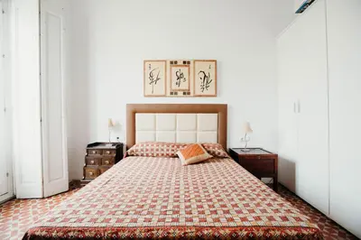 a bedroom with a large bed with a checkered blanket at Apartamento El Balcon de Cadiz in Cádiz