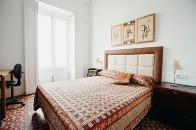 a bedroom with a bed and a desk and a window at Apartamento El Balcon de Cadiz in Cádiz