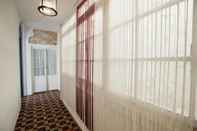 a hallway with a wall of windows and a door at Apartamento El Balcon de Cadiz in Cádiz