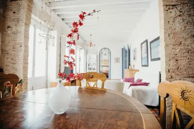 a white vase on a wooden table with flowers in it at Apartamento El Balcon de Cadiz in Cádiz