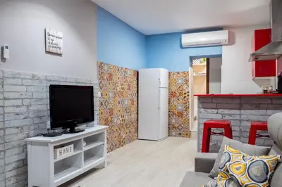 a living room with a tv and a kitchen at Apartamento Maribel in Cádiz