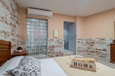 a bedroom with a bed and a brick wall at Apartamento Maribel in Cádiz