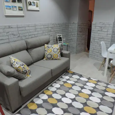 a living room with a couch and a rug at Apartamento Maribel in Cádiz