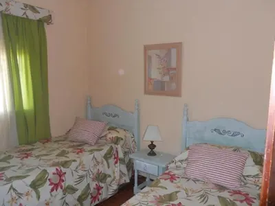 a bedroom with two twin beds and a table with a lamp at Macondo La barrosa in Chiclana de la Frontera