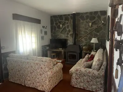 a living room with two chairs and a fireplace at Macondo La barrosa in Chiclana de la Frontera