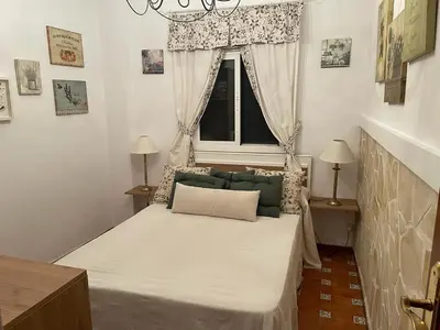 a small bedroom with a bed with a window at Macondo La barrosa in Chiclana de la Frontera