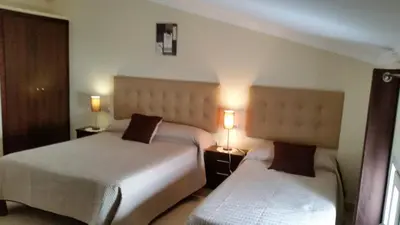 a hotel room with two beds and two lamps at Hostal Málaga in Arcos de la Frontera