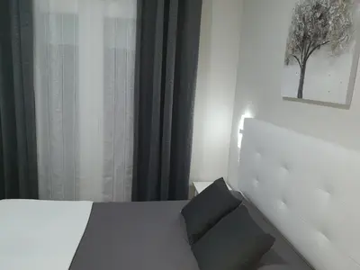 a bedroom with a white bed with a black pillow at Hostal Málaga in Arcos de la Frontera