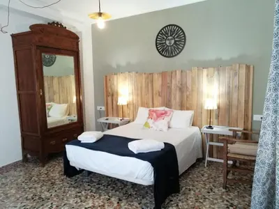 a bedroom with a large bed and a mirror at Casa Algarabía in Sanlúcar de Barrameda
