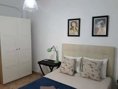 a bedroom with a bed and two pictures on the wall at Casa Algarabía in Sanlúcar de Barrameda
