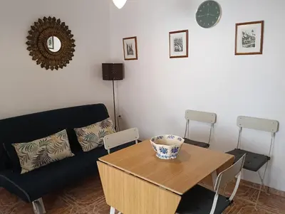 a living room with a table and a couch at Casa Algarabía in Sanlúcar de Barrameda