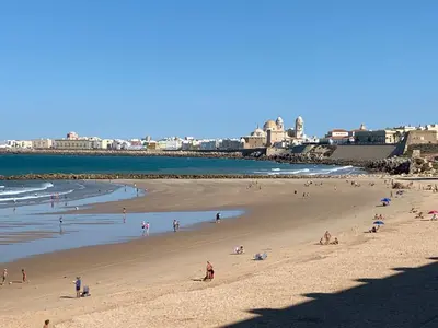 a group of people on a beach near the ocean at Loft Playa Santa María (Cádiz) in Cádiz