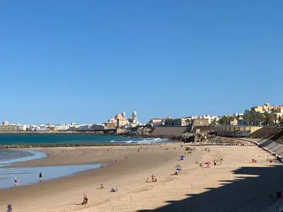 a group of people on a beach near the ocean at Loft Playa Santa María (Cádiz) in Cádiz