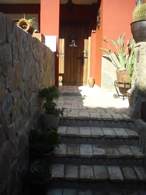 a stone staircase leading to a house with a wooden door at La Posada de Menchu in Sanlúcar de Barrameda