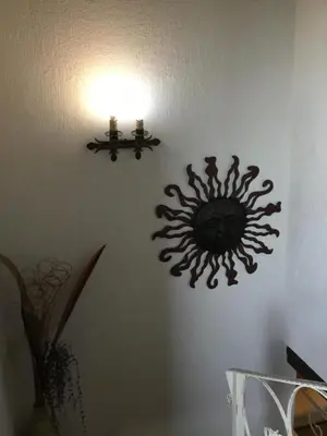 a clock on a wall with a light on a wall at La Posada de Menchu in Sanlúcar de Barrameda