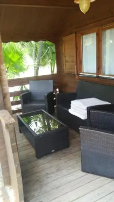 a patio with wicker furniture and a table and chairs at Bungalows y Glamping Medina Sidonia in Medina Sidonia