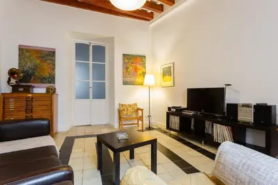 a kitchen with a wooden table and red cabinets at GuestReady - Arbolí Cadiz in Cádiz