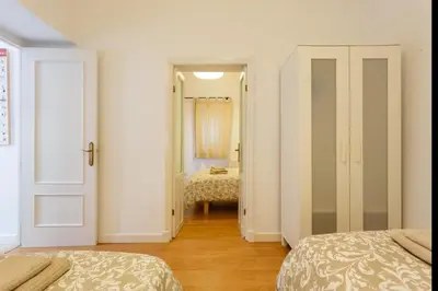 a white room with two beds and a mirror at GuestReady - Arbolí Cadiz in Cádiz