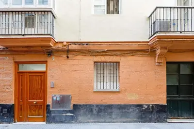 a building with a wooden door and windows at GuestReady - Arbolí Cadiz in Cádiz