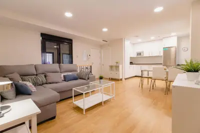 a living room and kitchen with a couch and a table at Apartamento Duplex La Estrella in Cádiz