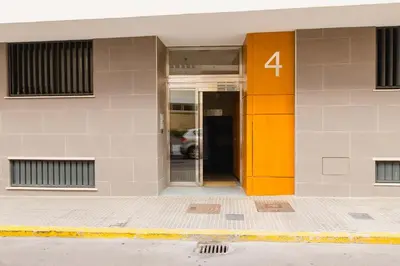 an orange door of a building with the number four at Apartamento Duplex La Estrella in Cádiz