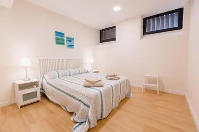 a bedroom with a bed with a striped blanket at Apartamento Duplex La Estrella in Cádiz