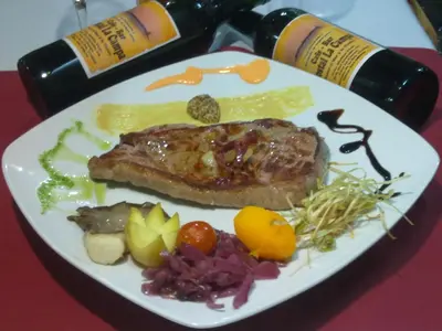 a plate of food with meat and vegetables on a table at Hostal la Campa in Chiclana de la Frontera
