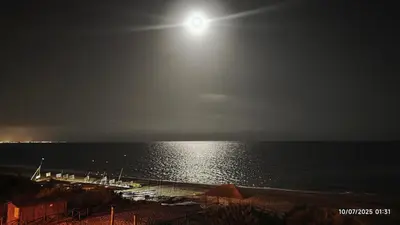 a view of the ocean at night with the moon at Espectacular ático en 1°linea playa in Rota
