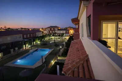 a view of a swimming pool at night from a building at Espectacular ático en 1°linea playa in Rota