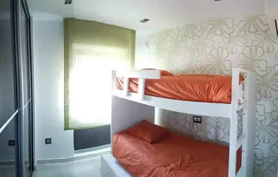 two bunk beds in a room with a window at Espectacular ático en 1°linea playa in Rota