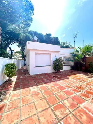 a house with a brick patio and a white fence at Chalet La Caballa Playa la Barrosa in Chiclana de la Frontera