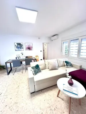 a living room with a white couch and a table at Chalet La Caballa Playa la Barrosa in Chiclana de la Frontera
