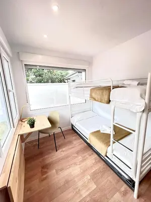 a room with two bunk beds and a desk at Chalet La Caballa Playa la Barrosa in Chiclana de la Frontera