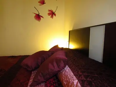 a bedroom with a bed with flowers on the wall at Mi pequeño apartamento in Cádiz
