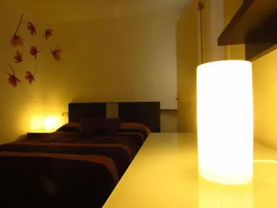 a bedroom with two beds and a table with a lamp at Mi pequeño apartamento in Cádiz