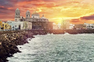 a group of buildings on the beach with the ocean at Mi pequeño apartamento in Cádiz