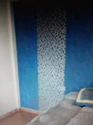 a room with a blue wall and a wall that is under construction at VIVIENDA TURISTICA MARANt 2 in El Puerto de Santa María