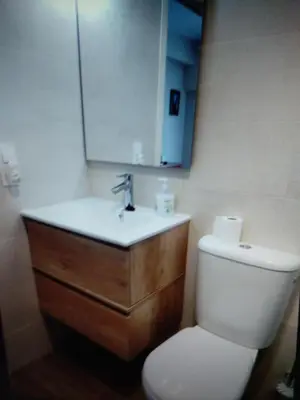 a bathroom with a toilet and a sink with a mirror at VIVIENDA TURISTICA MARANt 2 in El Puerto de Santa María