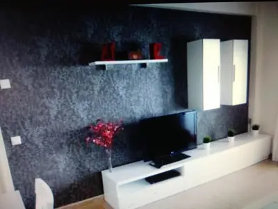 a living room with a tv on a black wall at VIVIENDA TURISTICA MARANt 2 in El Puerto de Santa María